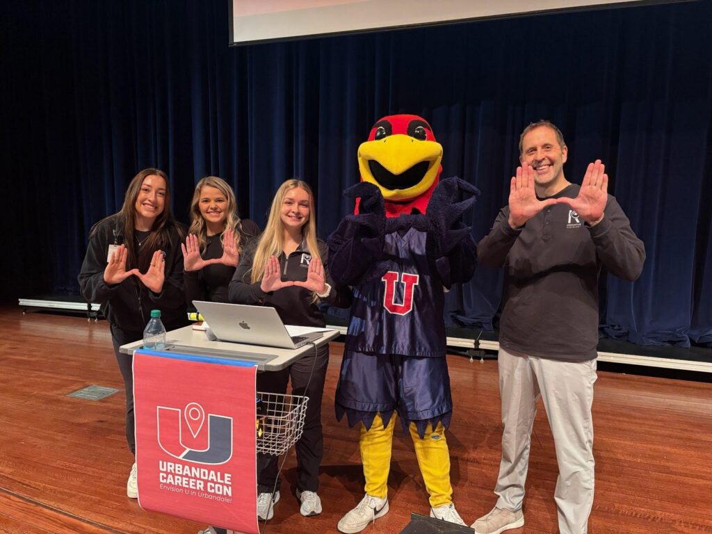 John Tenniger and his staff posing with the school mascot at Urbandale Career Con.