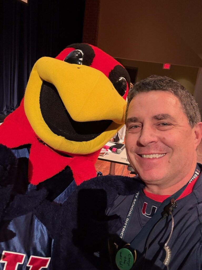 Principal Carver taking a selfie with the school mascot.