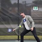 Man wearing green jacket and Urbandale Flag shirt playing pickleball at Lions Park pickleball courts in Urbandale