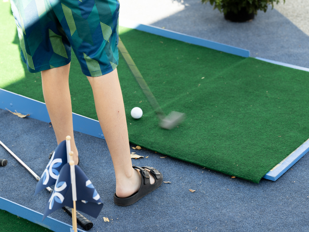 Young child playing mini golf