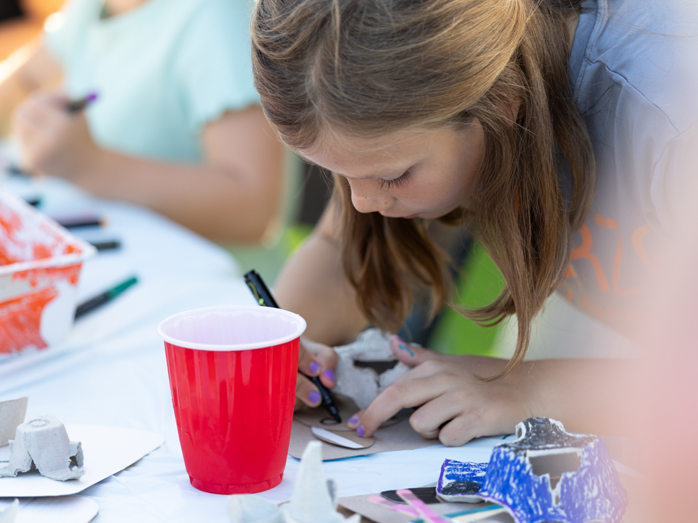 Young girl doing arts and crafts at Downtown Urbandale Block Party