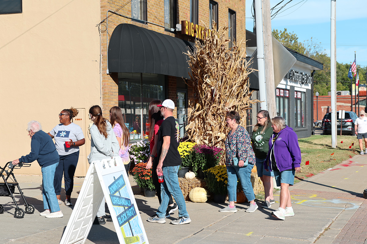 Downtown Urbandale with people walking into venue